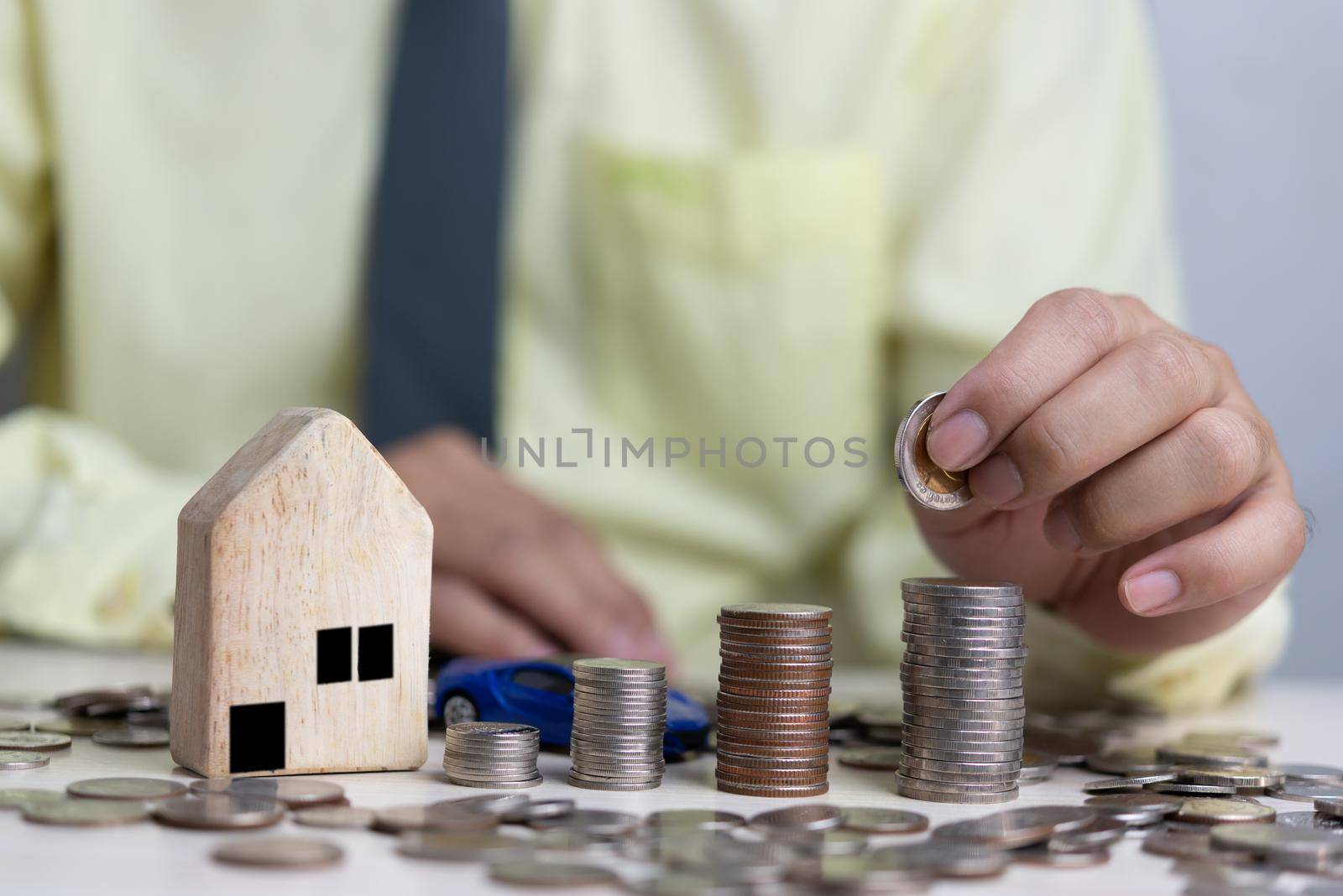 Real estate concept business, home insurance and real estate protection. Buy and sell houses and real estate online. Man holding coin stack on desk. by aoo3771