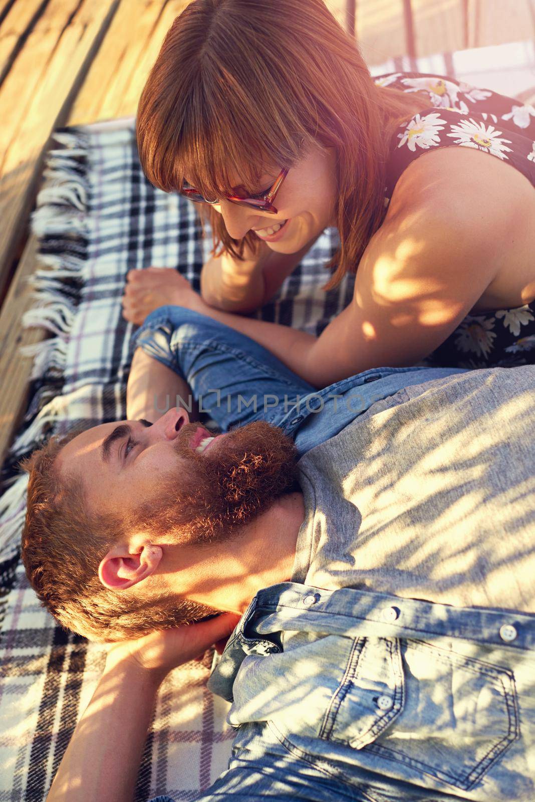 Everyday is perfect together. an affectionate young couple lying on a blanket outdoors