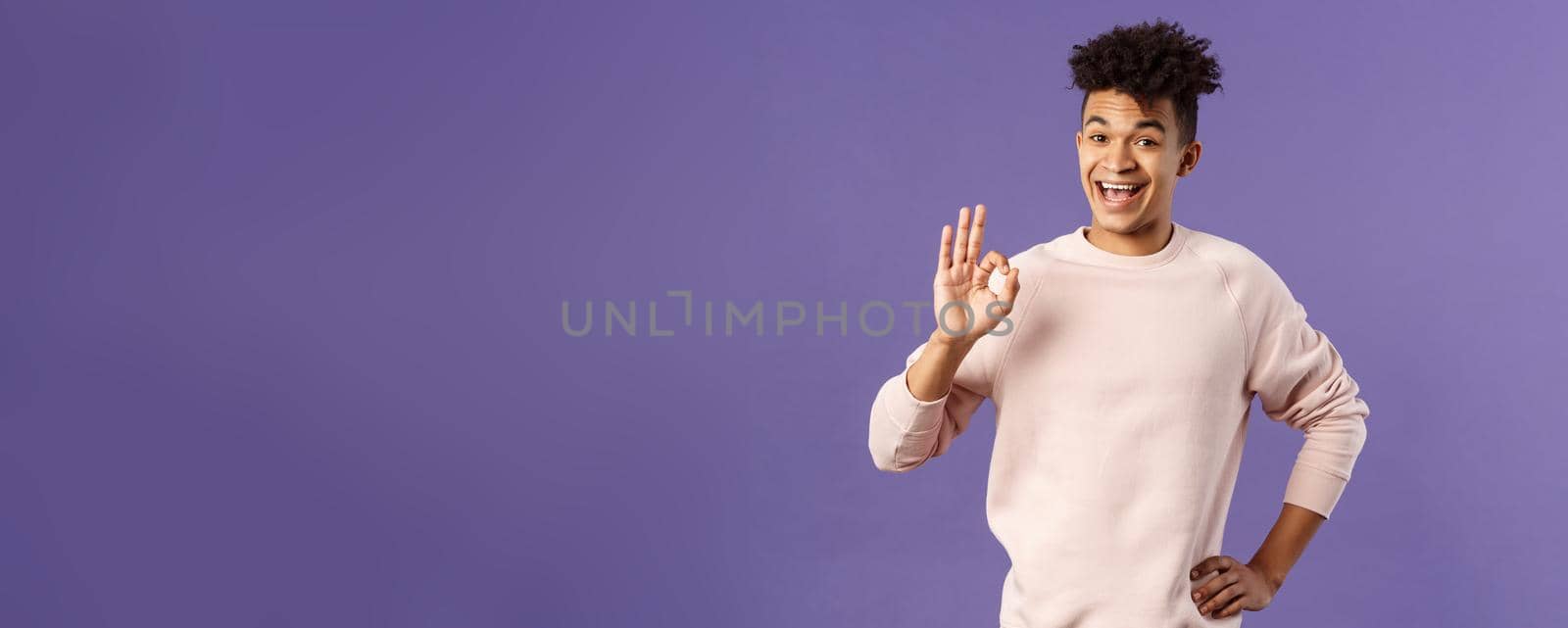 Relax its okay. Portrait of carefree, unbothered young man have everything under control, assure and guarantee job will be done, recommend product, being pleased, purple background.