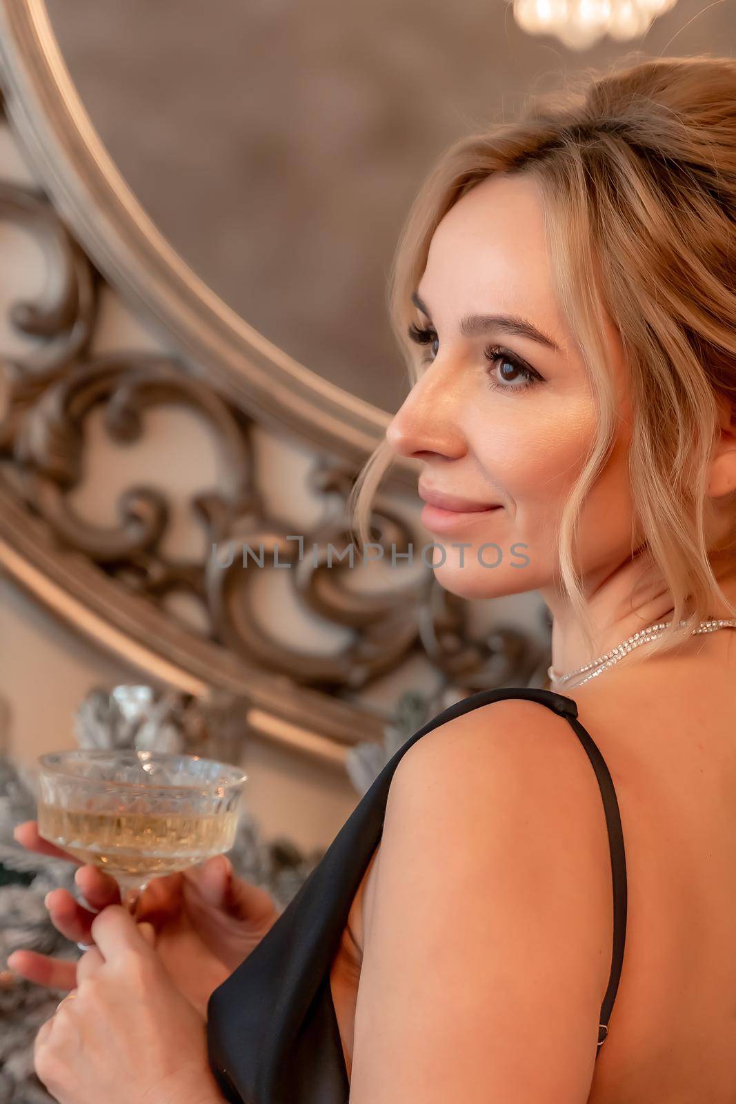 Portrait of a wealthy mature woman with evening makeup and hairstyle posing in a black dress against the backdrop of a Christmas room. Luxurious lifestyle. Cosmetology, plastic surgery, rejuvenation