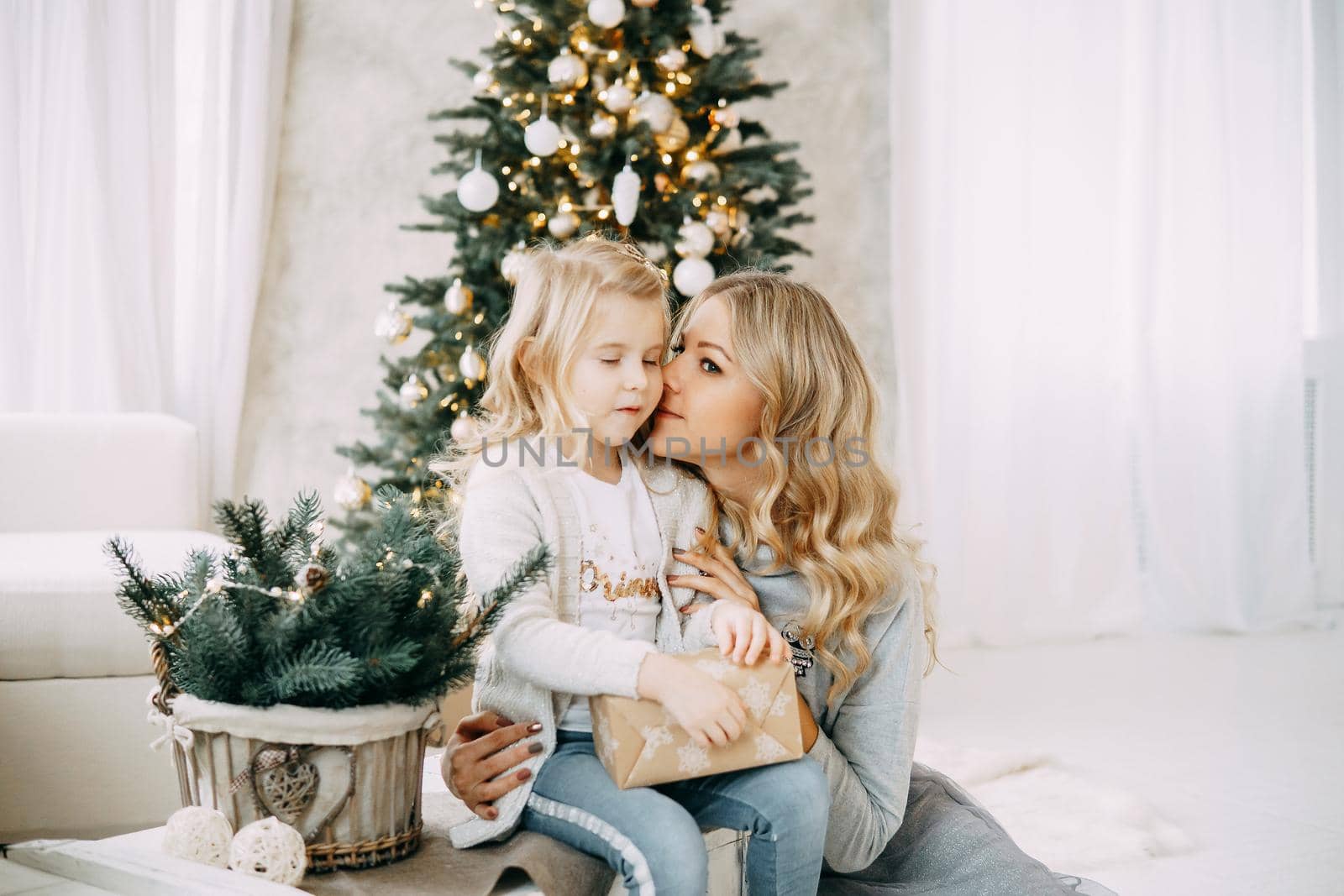 Happy family: mother and daughter. Family in a bright New Year's interior with a Christmas tree by Annu1tochka