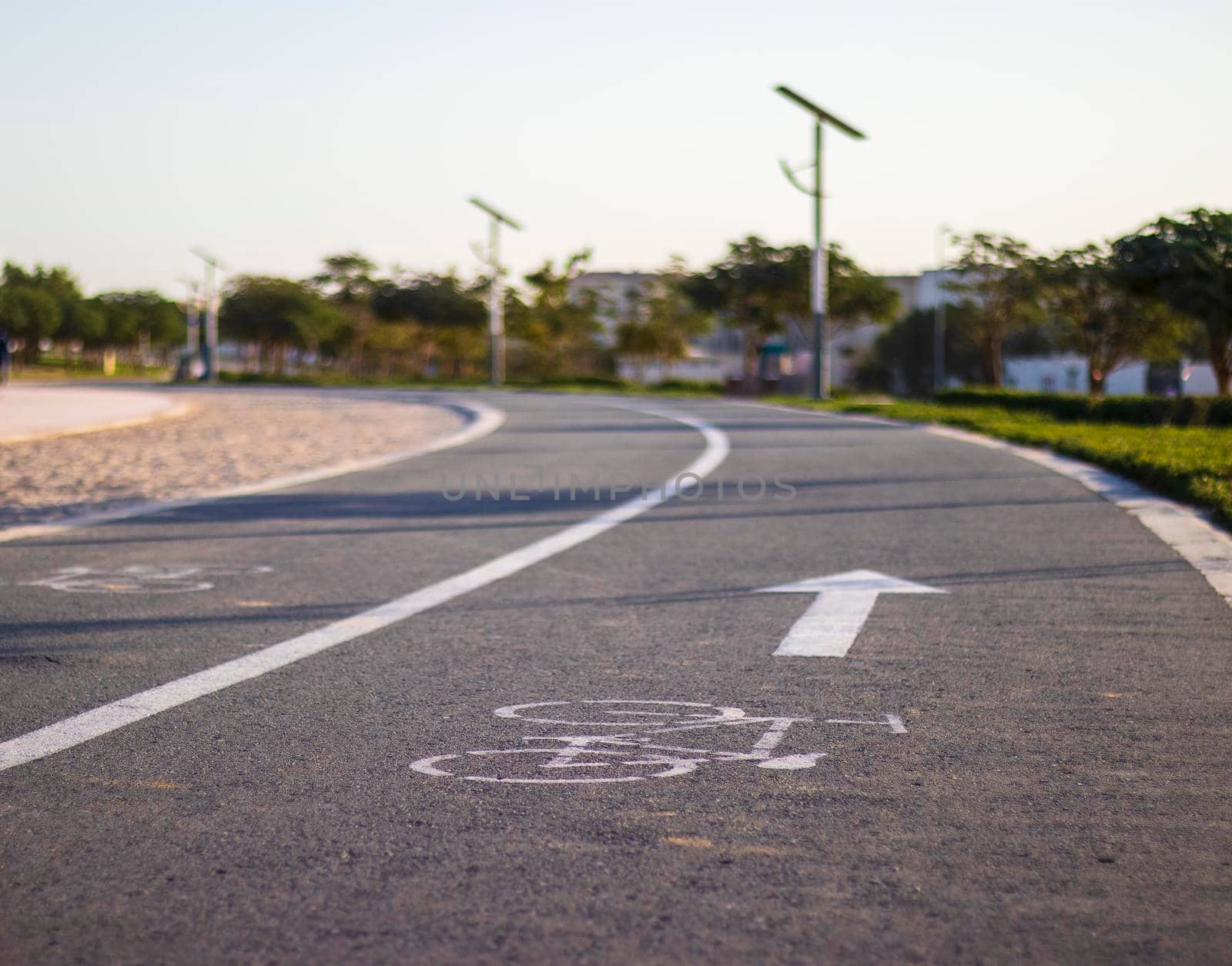 Jogging and cycling tracks in Al Warqa park, Dubai, UAE early in the morning. Lamp post powered by solar panels can be seen in the picture.