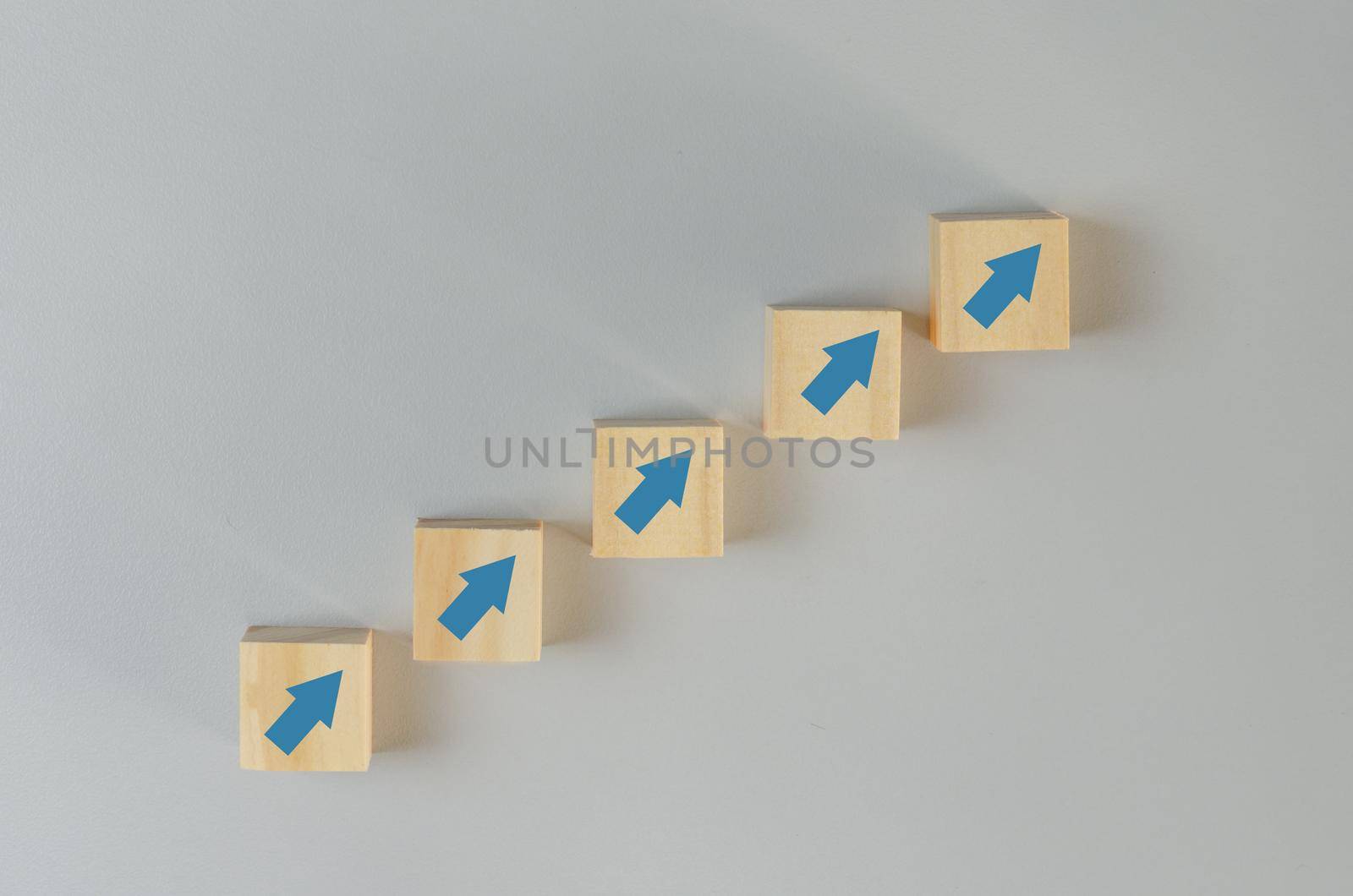 Business growth development increase revenue investment finance with wood cube block arrow on background.