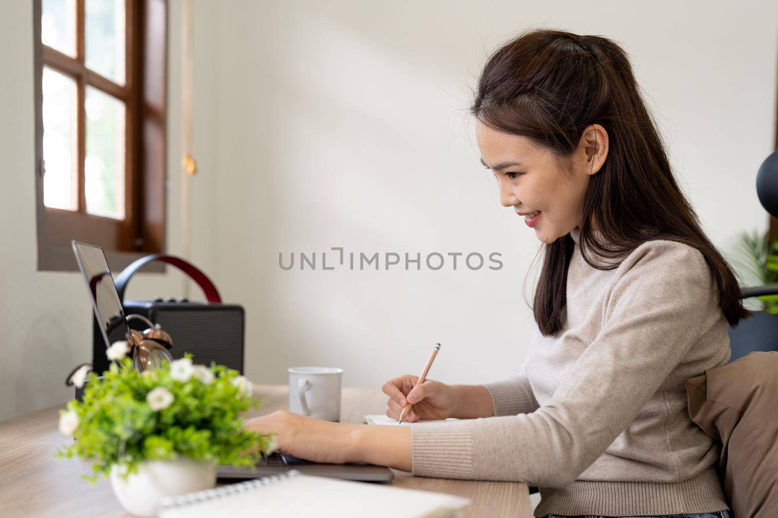 woman wearing using laptop in cafe, writing notes, attractive female student learning language, watching online webinar, listening audio course, e-learning education concept. by nateemee