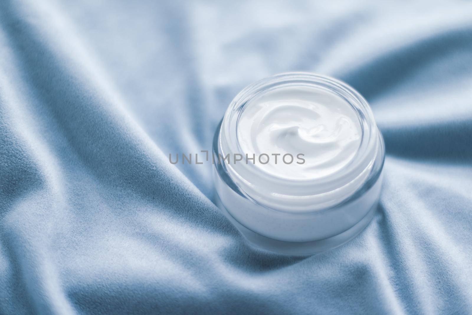 Beauty, anti-age cosmetics and skincare concept - Luxury face cream jar on blue silk