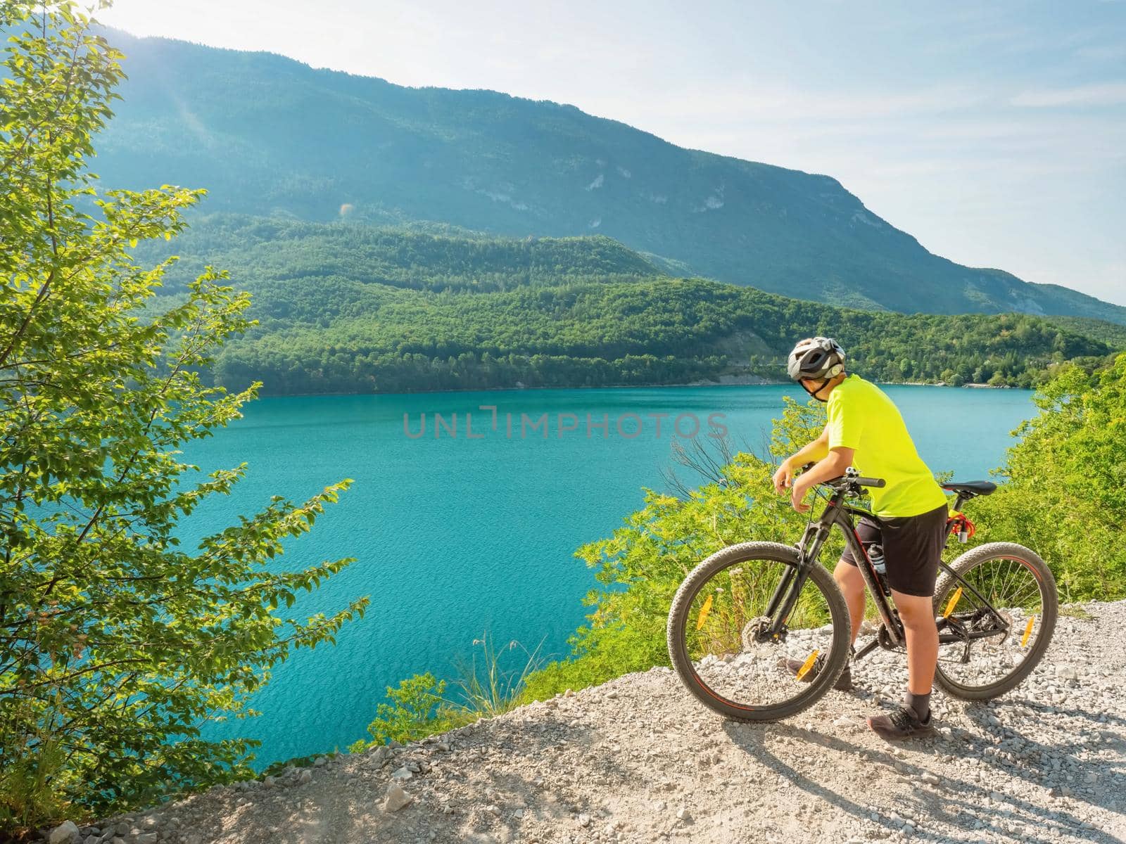 Young biker looking over Molveno lake from gravel trail round around by rdonar2