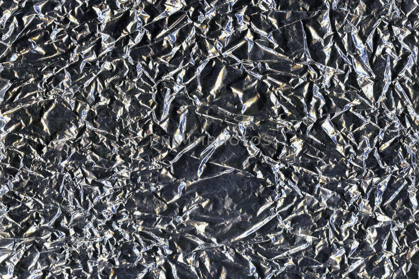 Silver crumpled aluminum foil flat background and texture. Shiny surface