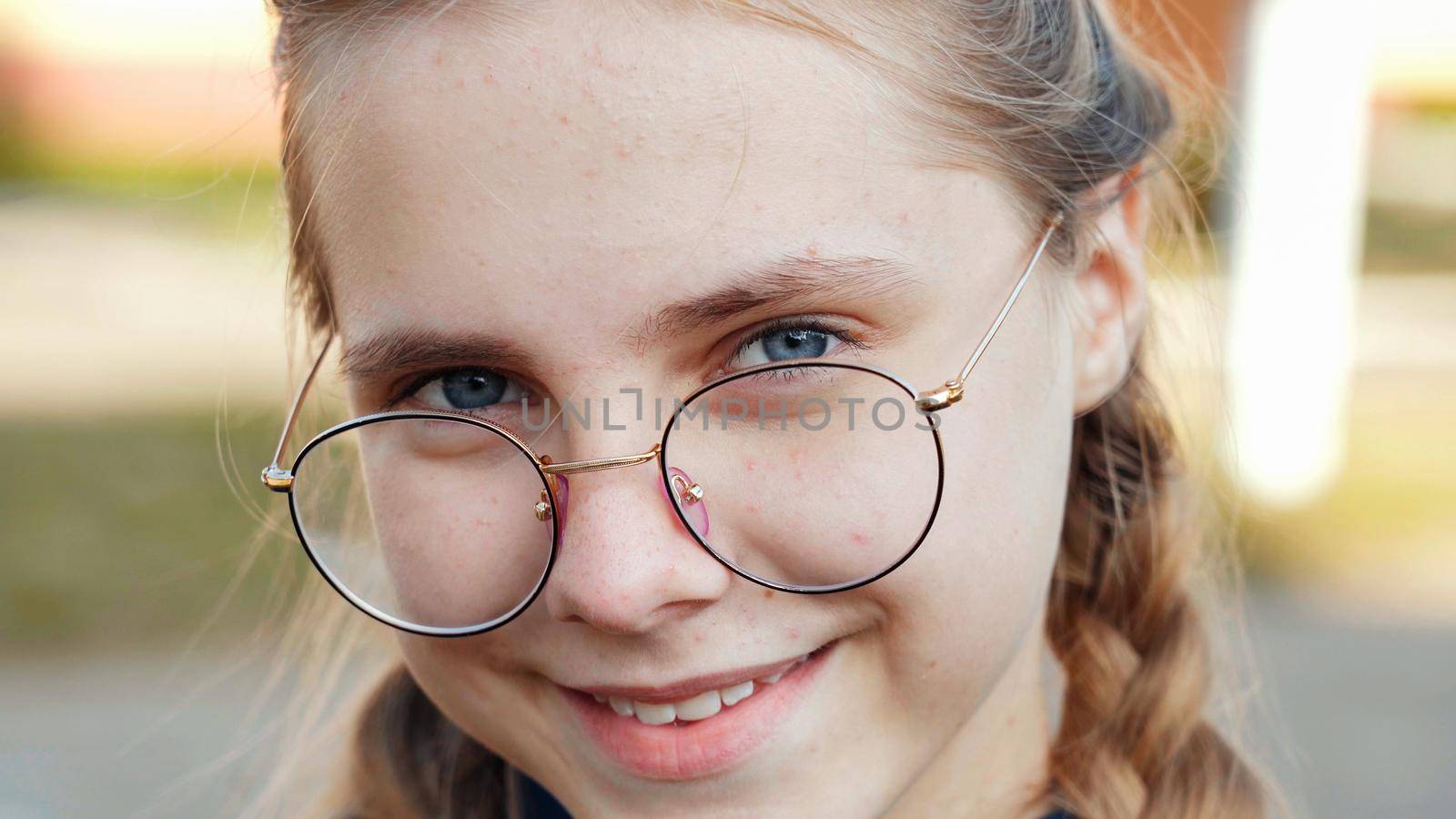 A teenage girl wearing glasses. Close-up of her face