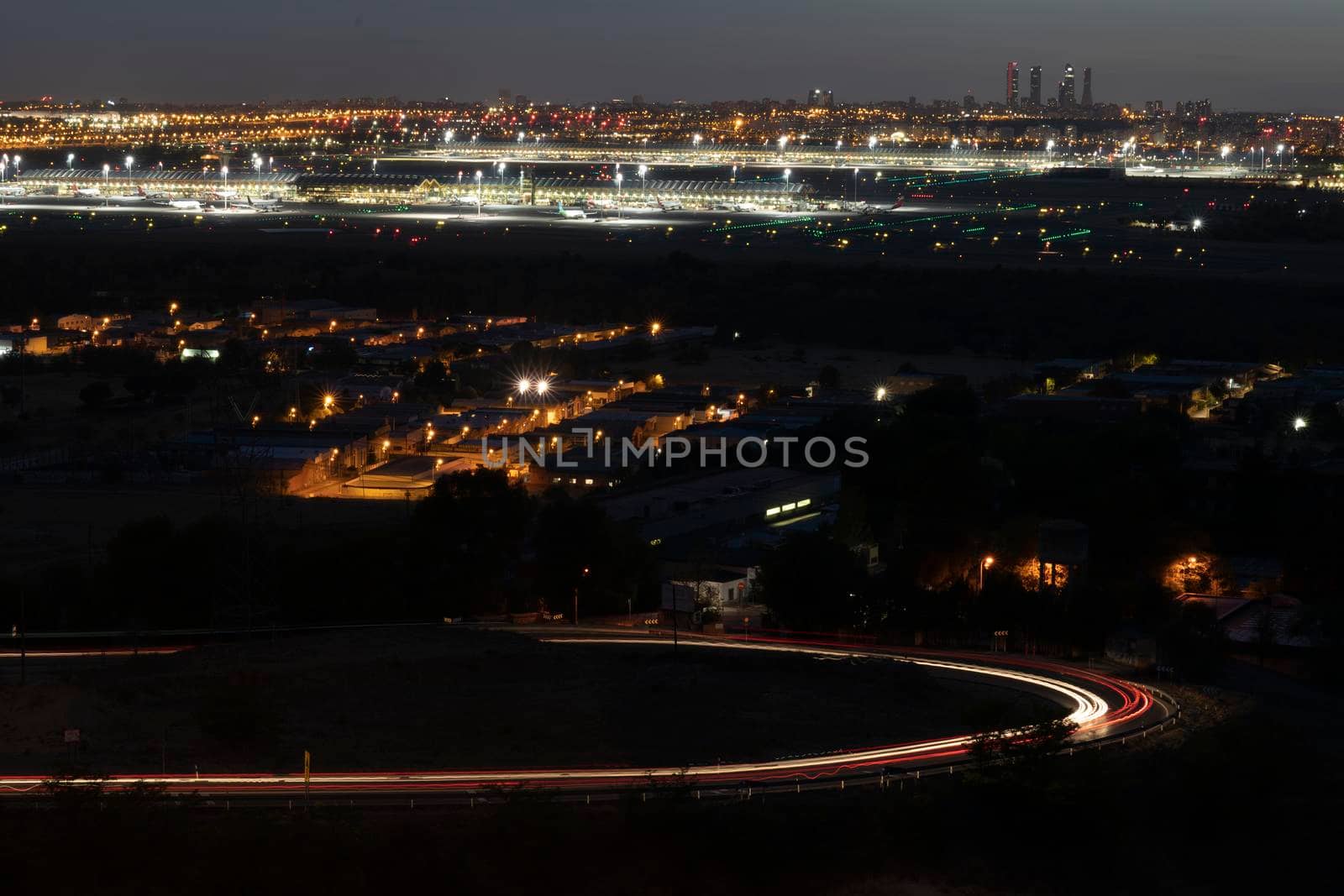 Madrid skyline at night. Barajas airport and 4 towers in the background. Slow shutter of traffic. by papatonic