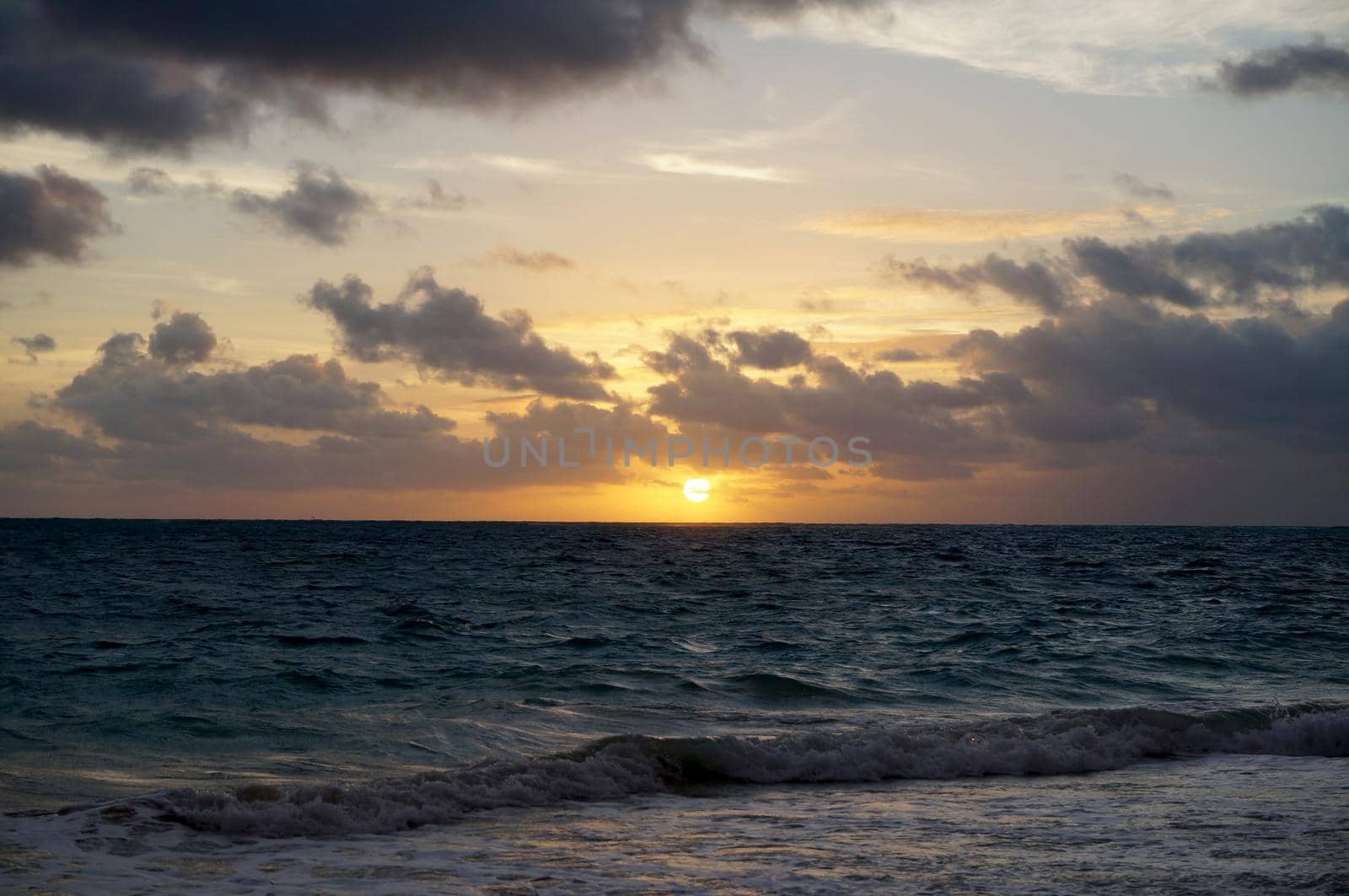 Sunrise over the ocean through the clouds on Waimanalo Beach  by EricGBVD