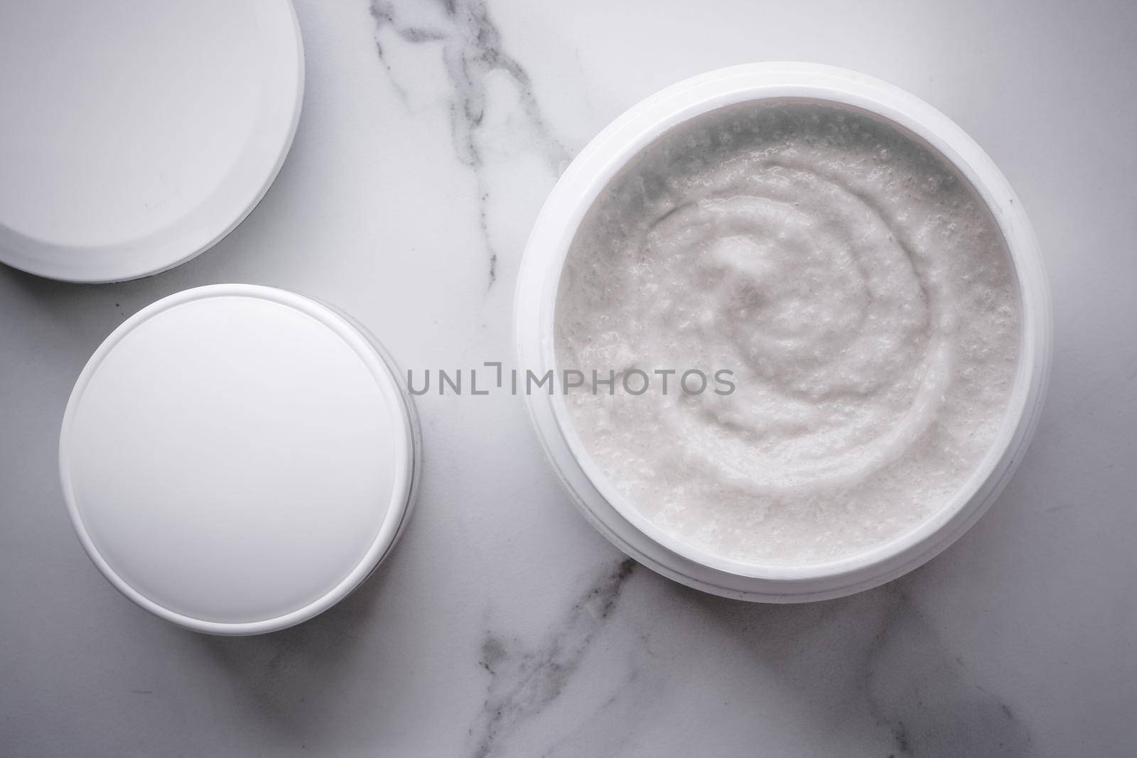 Scrub and exfoliating cream products on a marble, flatlay by Anneleven
