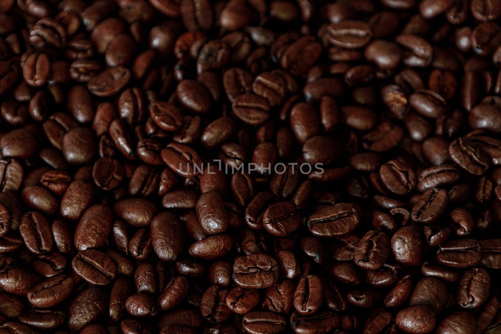 Brown Roasted Coffee Beans Closeup On Dark Background. High quality photo