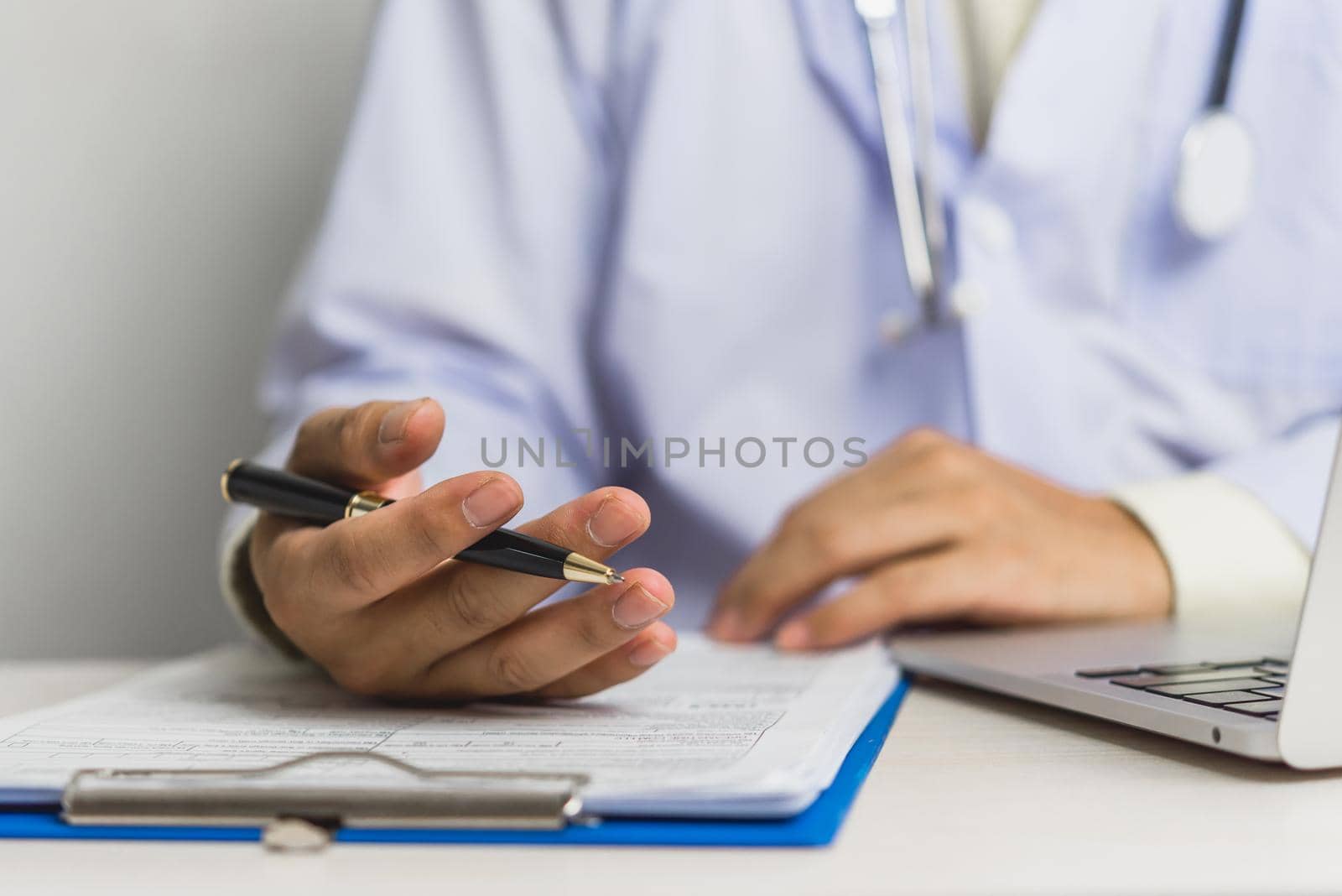 Doctor hand holding pen write and paperwork document patient treatment on clipboard.Business health care concept. by aoo3771
