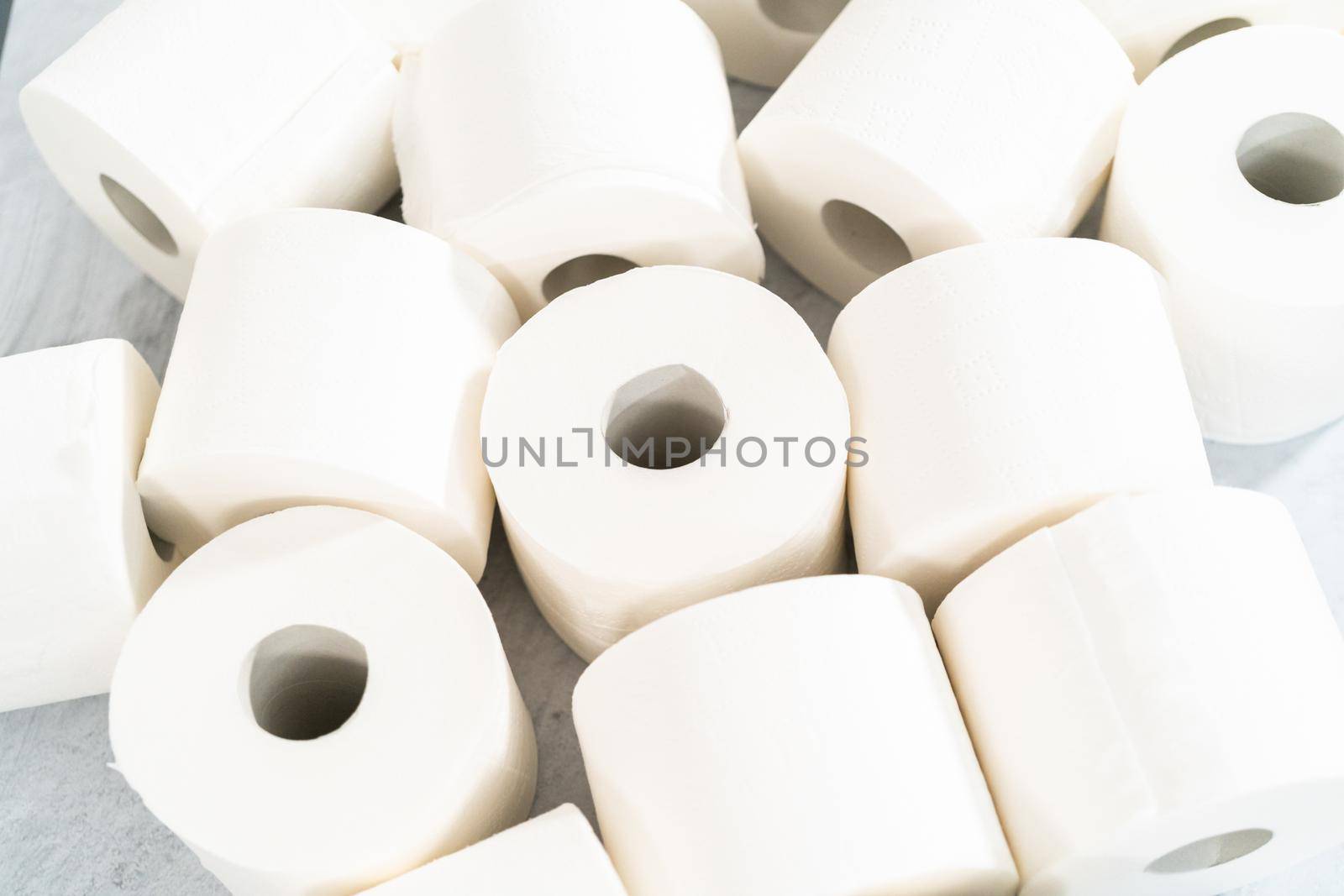 New white toilet paper rolls on a gray background.