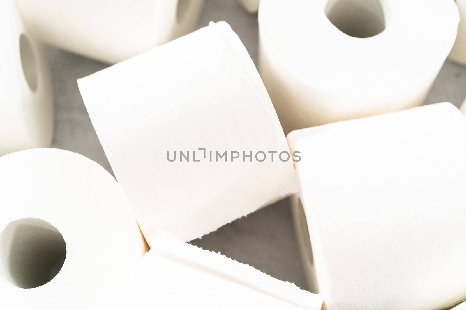New white toilet paper rolls on a gray background.