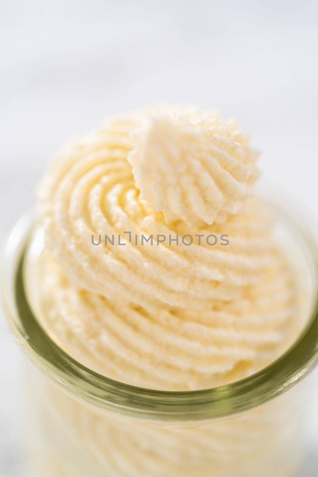 White chocolate ganache frosting in a small glass mason jar.