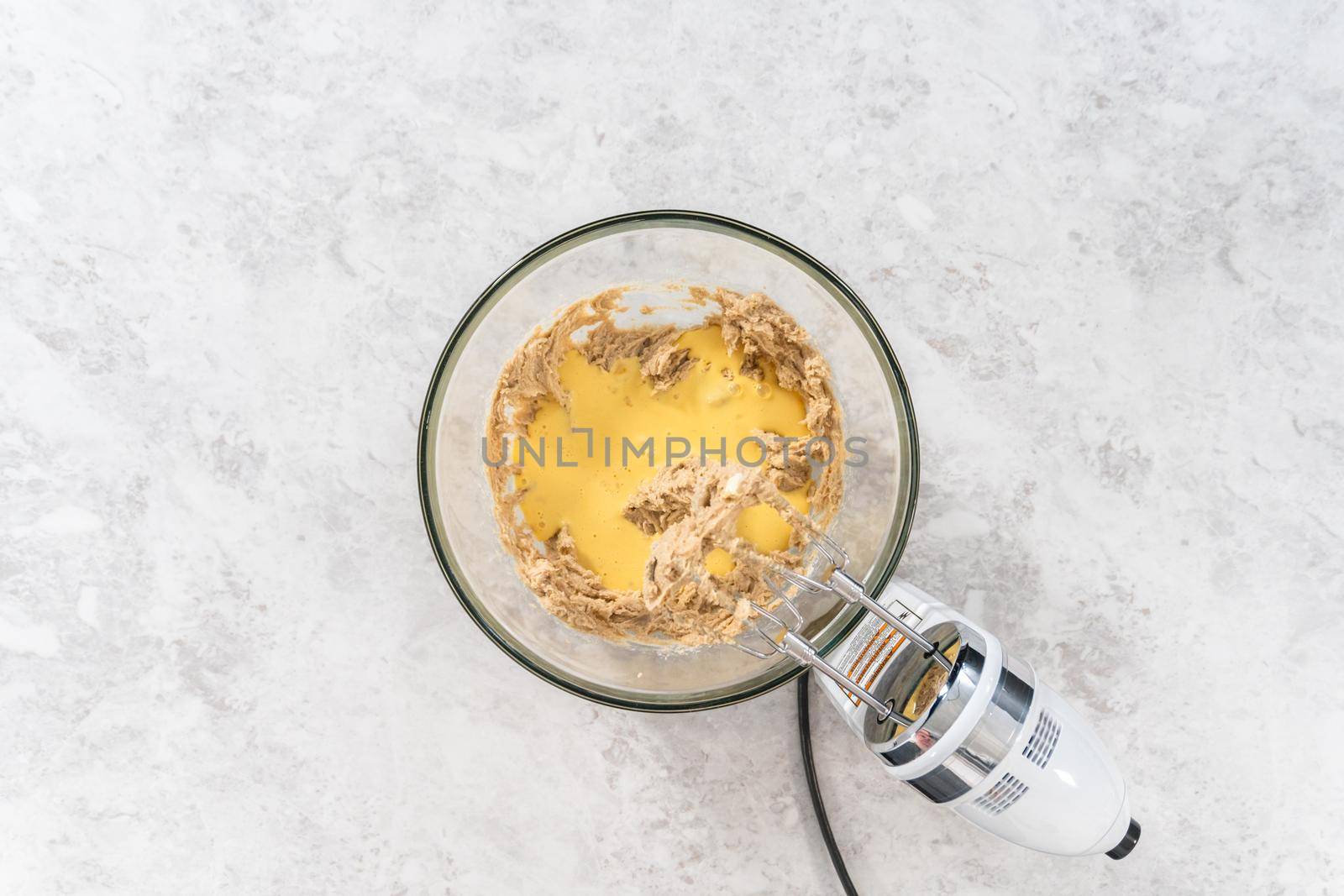 Flat lay. Mixing ingredients in a large glass mixing bowl to bake eggnog scones.