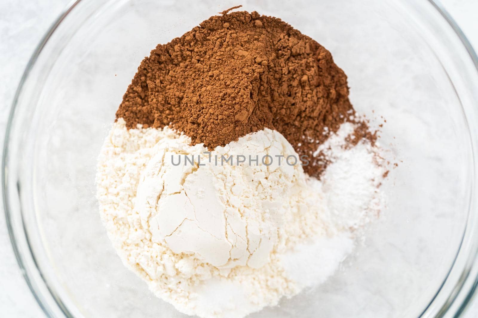 Mixing ingredients in a glass mixing bowl to bake s'mores cupcakes.