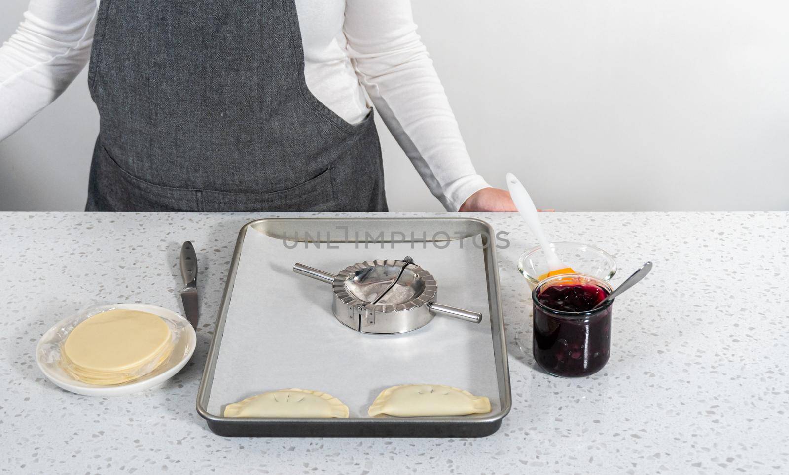 Filling empanada dough with blueberry pie filling to make sweet empanadas with blueberries.