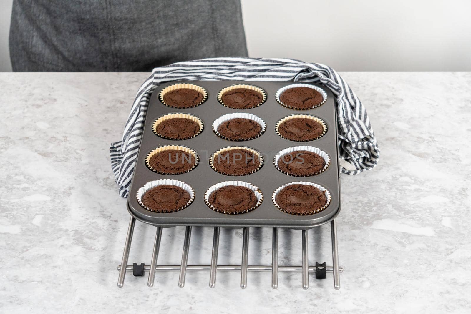 Cooling freshly baked s'mores cupcakes in a cupcake baking pan.
