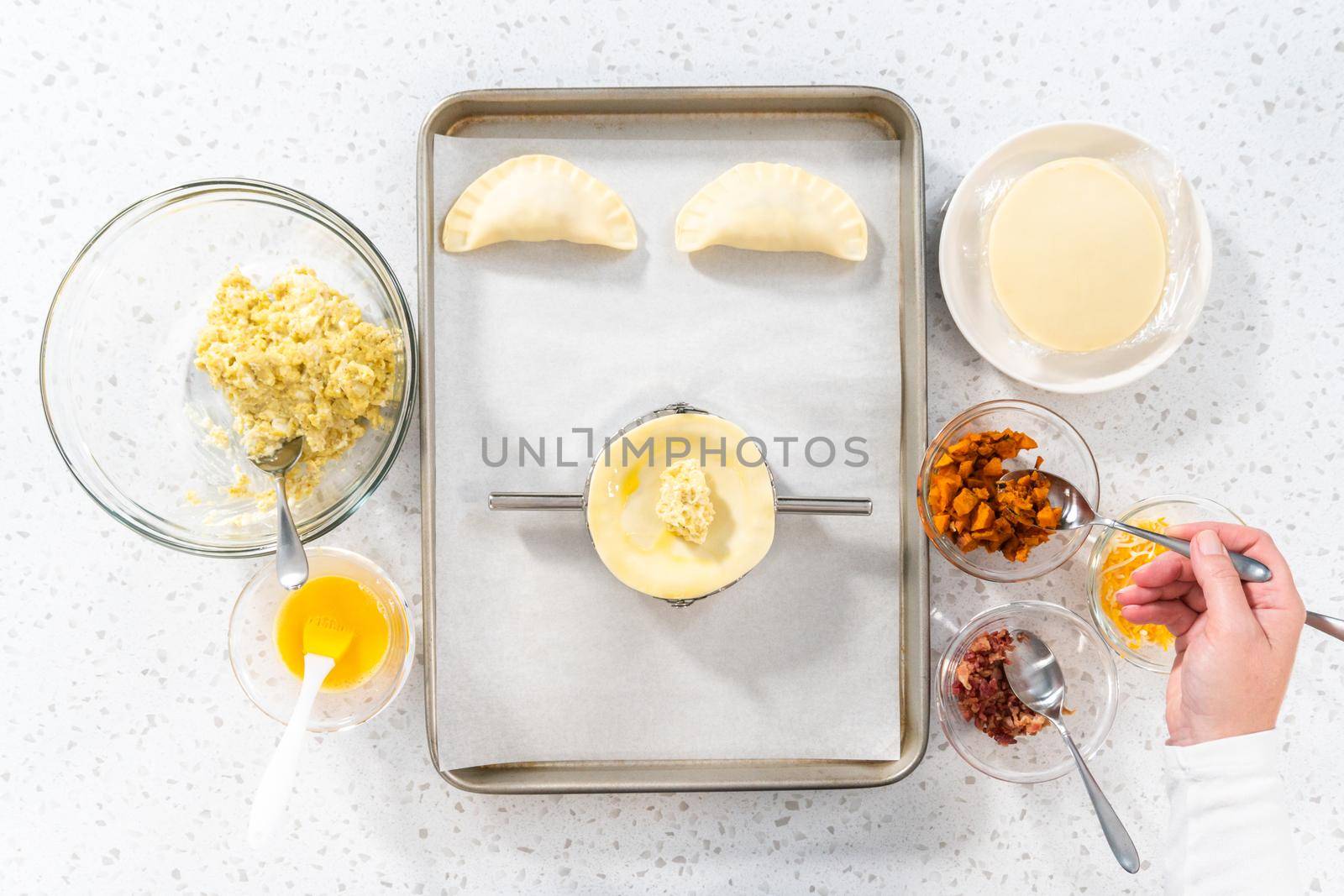 Flat lay. Filling empanada dough with egg filling to make breakfast empanadas with eggs and sweet potato.