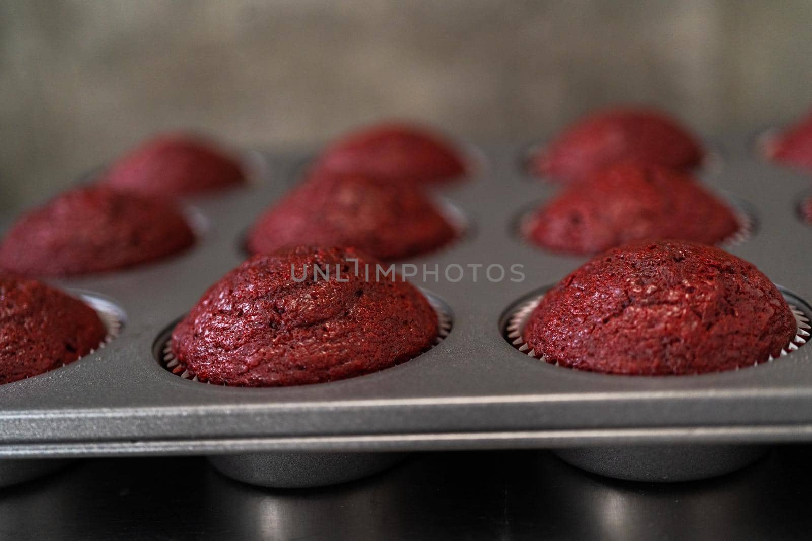 Cooling freshly baked red velvet cupcakes on a kitchen counter.