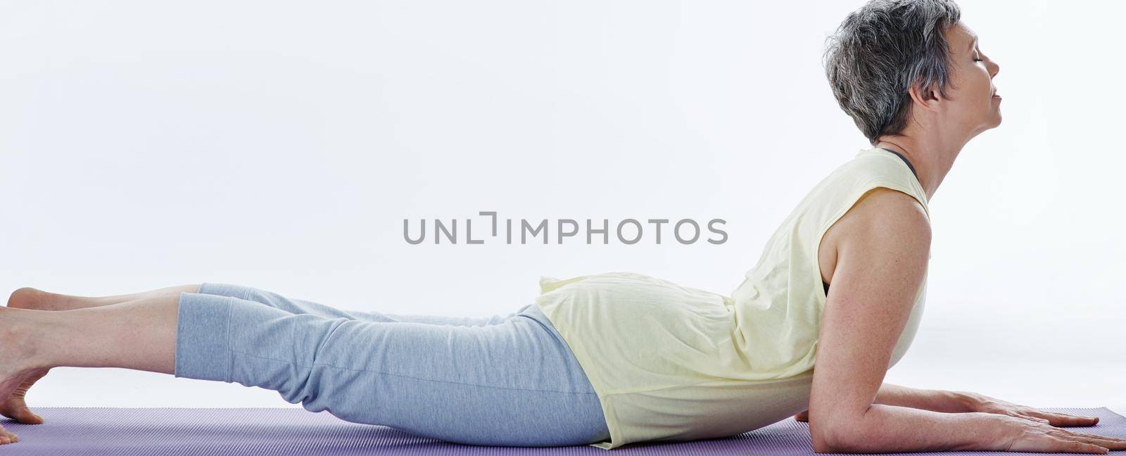 Stretch it out. Full length shot of an attractive woman stretching before yoga. by YuriArcurs