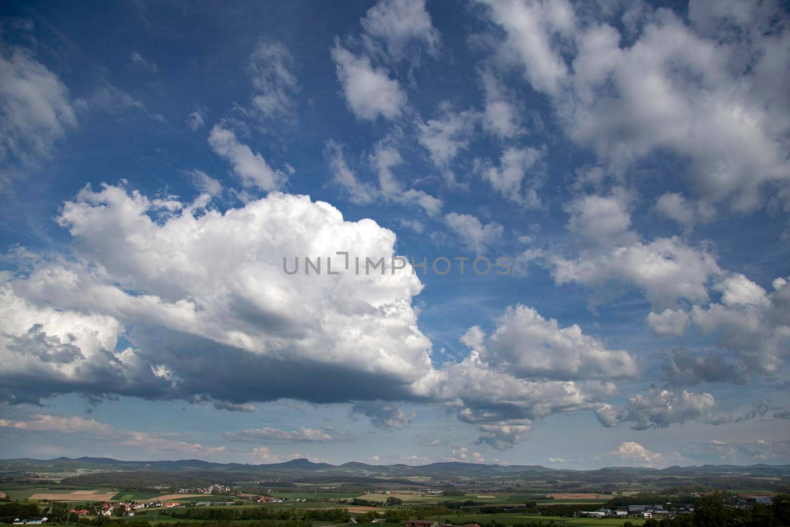 Beauty cloud against a blue sky background. Sky slouds. Blue sky with cloudy weather, nature cloud over the landskape. Over the land white clouds, blue sky and sun. High quality photo