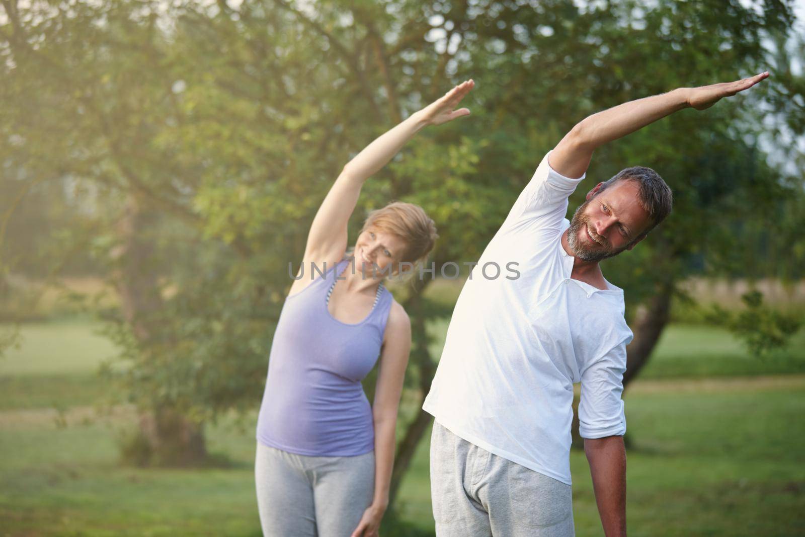 Their workout of choice. a happy mature couple doing yoga in nature