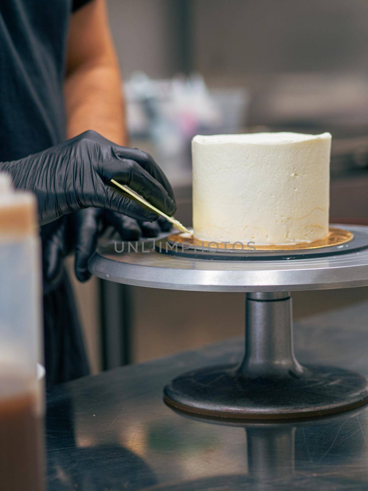 professional baker decorating a chocolate and cream cake with salty caramel