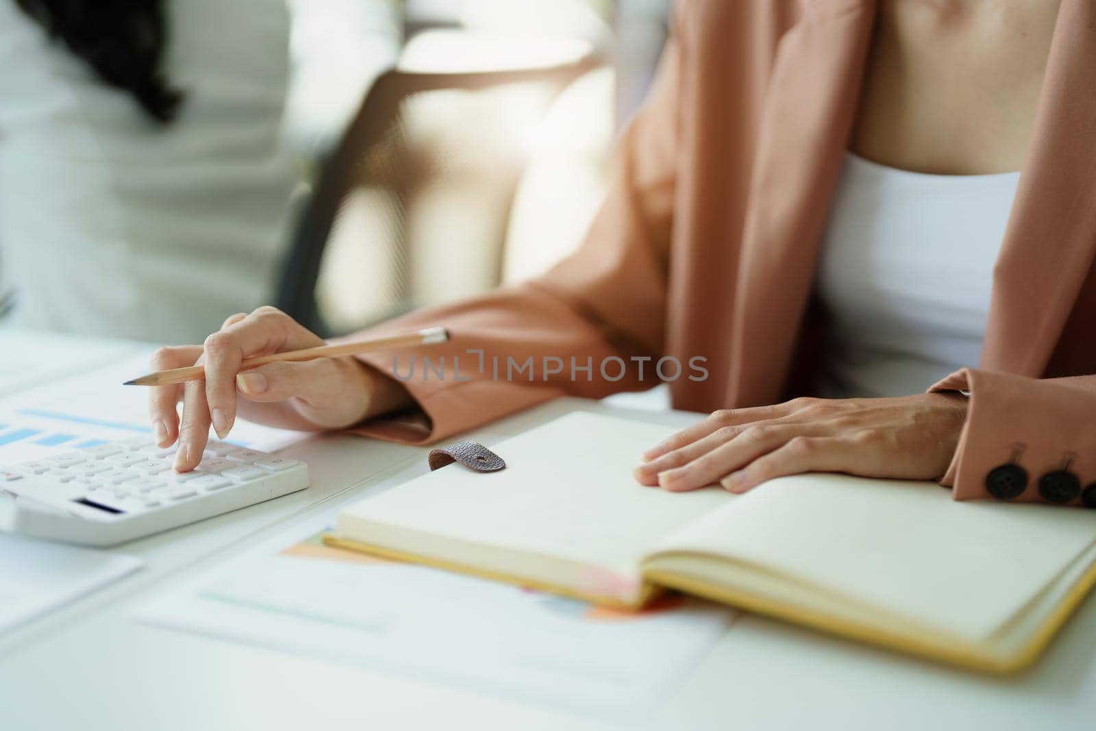 Accountants are using calculators for calculating financial documents, checking accounts and using notebooks to record their work.