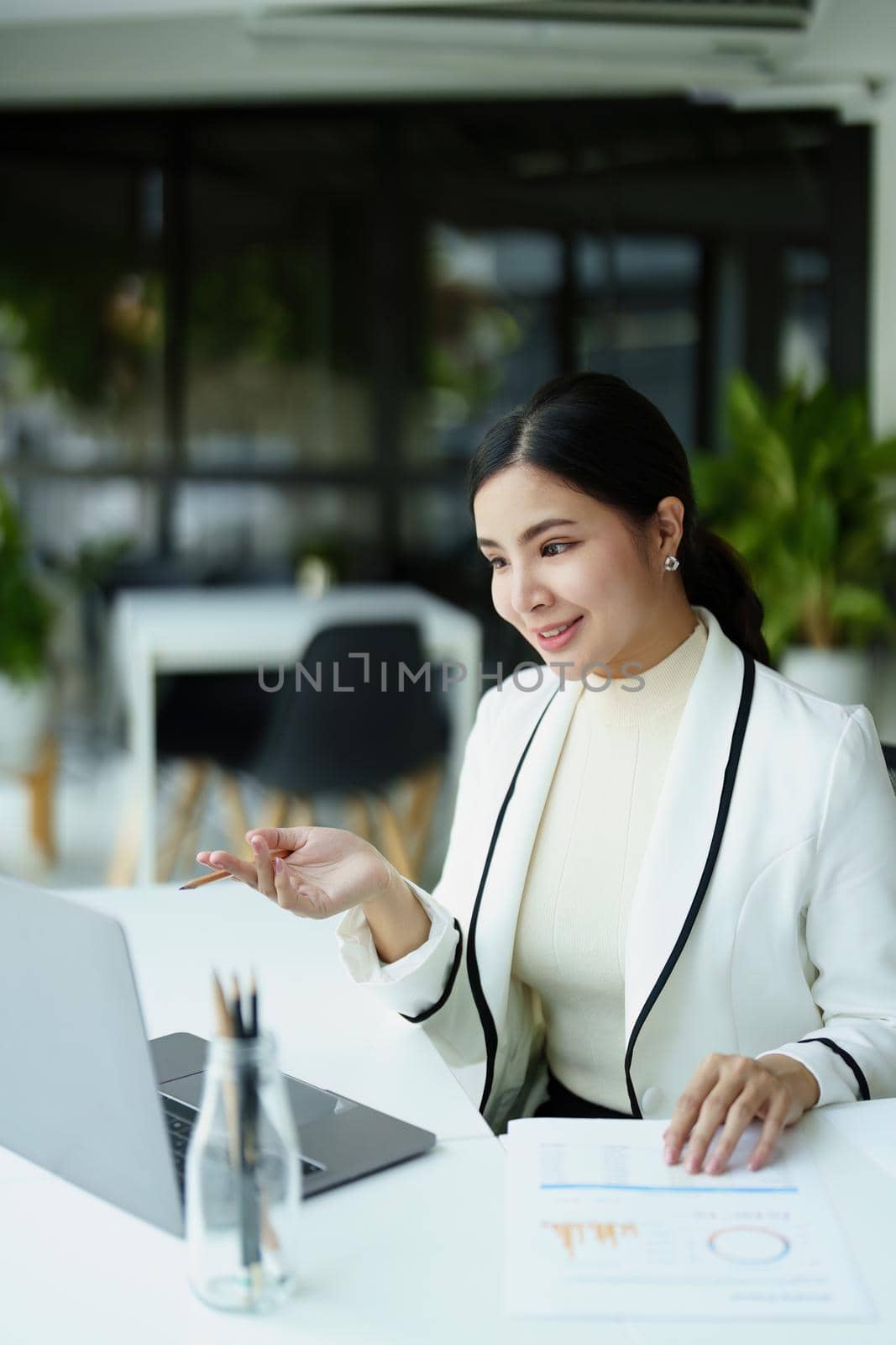 A portrait of a female employee using a computer video conferencing to discuss work through the Internet network.