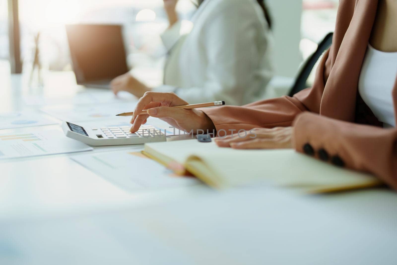 Accountants are using calculators for calculating financial documents, checking accounts and using notebooks to record their work.