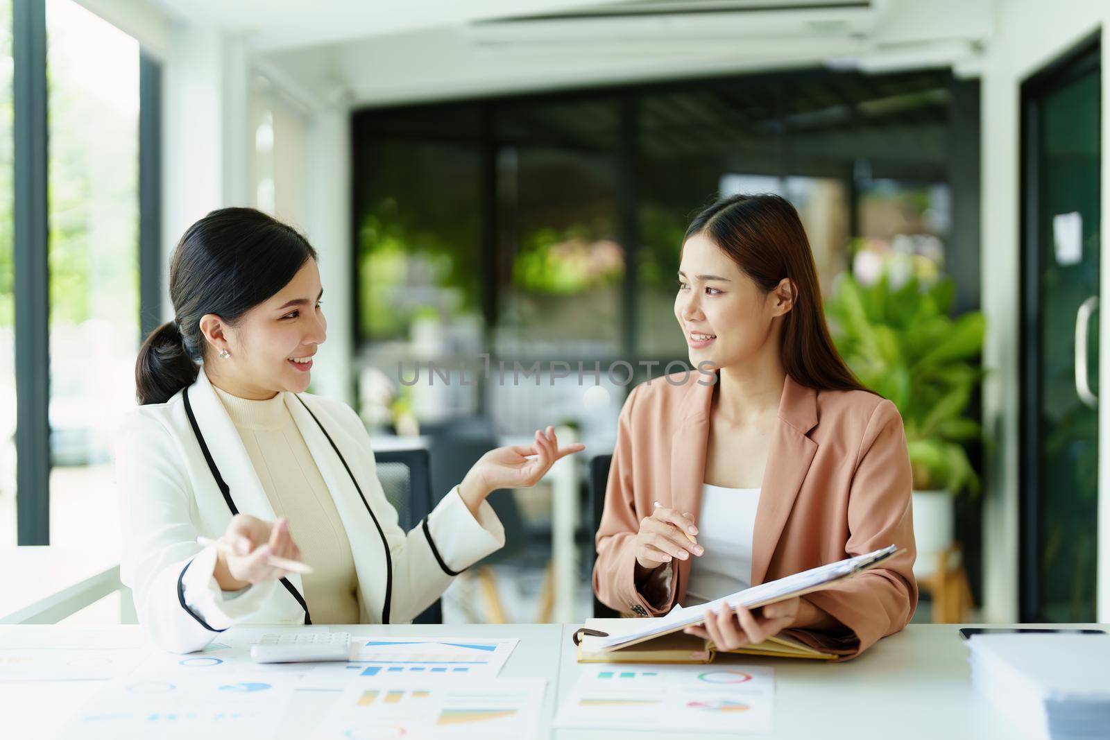 A portrait of a marketing employee and a salesperson using product documentation to plan sales.