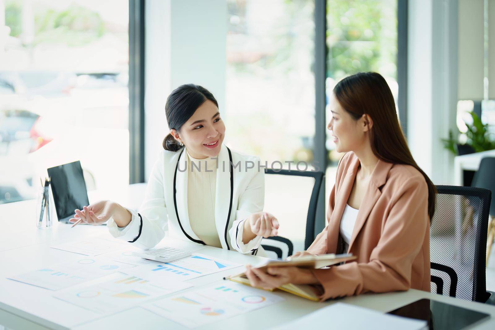 A portrait of a marketing employee and a salesperson using product documentation to plan sales.