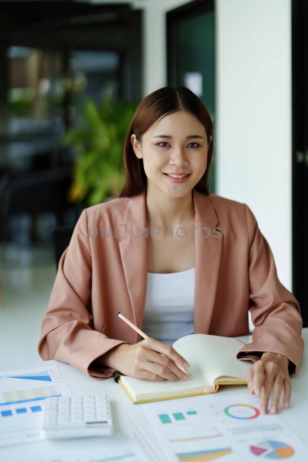 Accountants are using calculators for calculating financial documents, checking accounts and using notebooks to record their work.