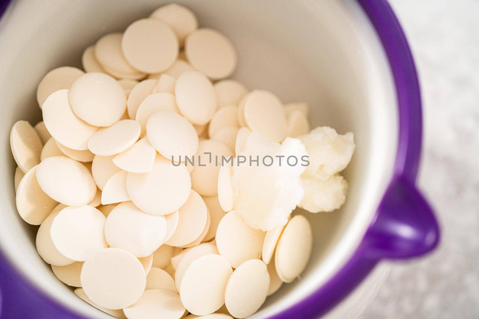 Melting white chocolate chips in a candy melting pot to drizzle over eggnog scones.