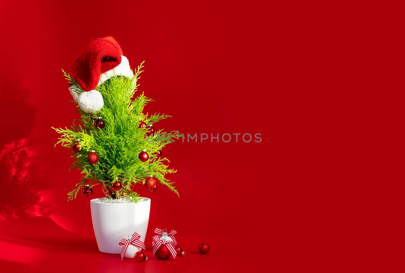 Big New Year banner on a red background. Small Christmas tree and decorations with copy paste for your product or text. new year banner concept, sale, new products and services