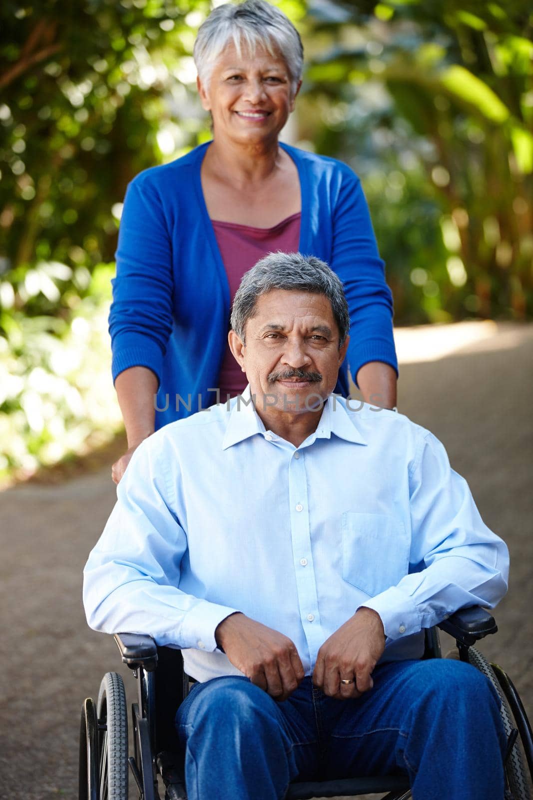 On the road to recovery. Portrait of a senior woman pushing her husband in a wheelchair outdoors