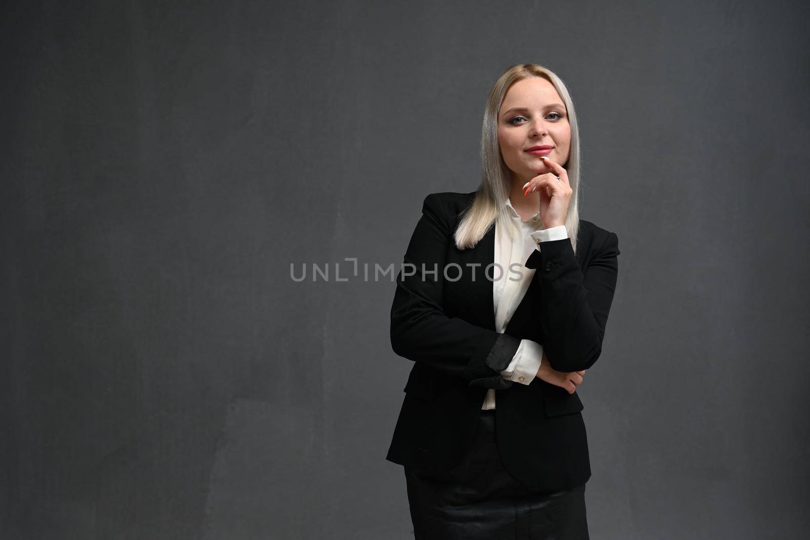 Beautiful blondy woman looking friendly and ready to help customer or client, holding hands together and staring at camera, gray background
