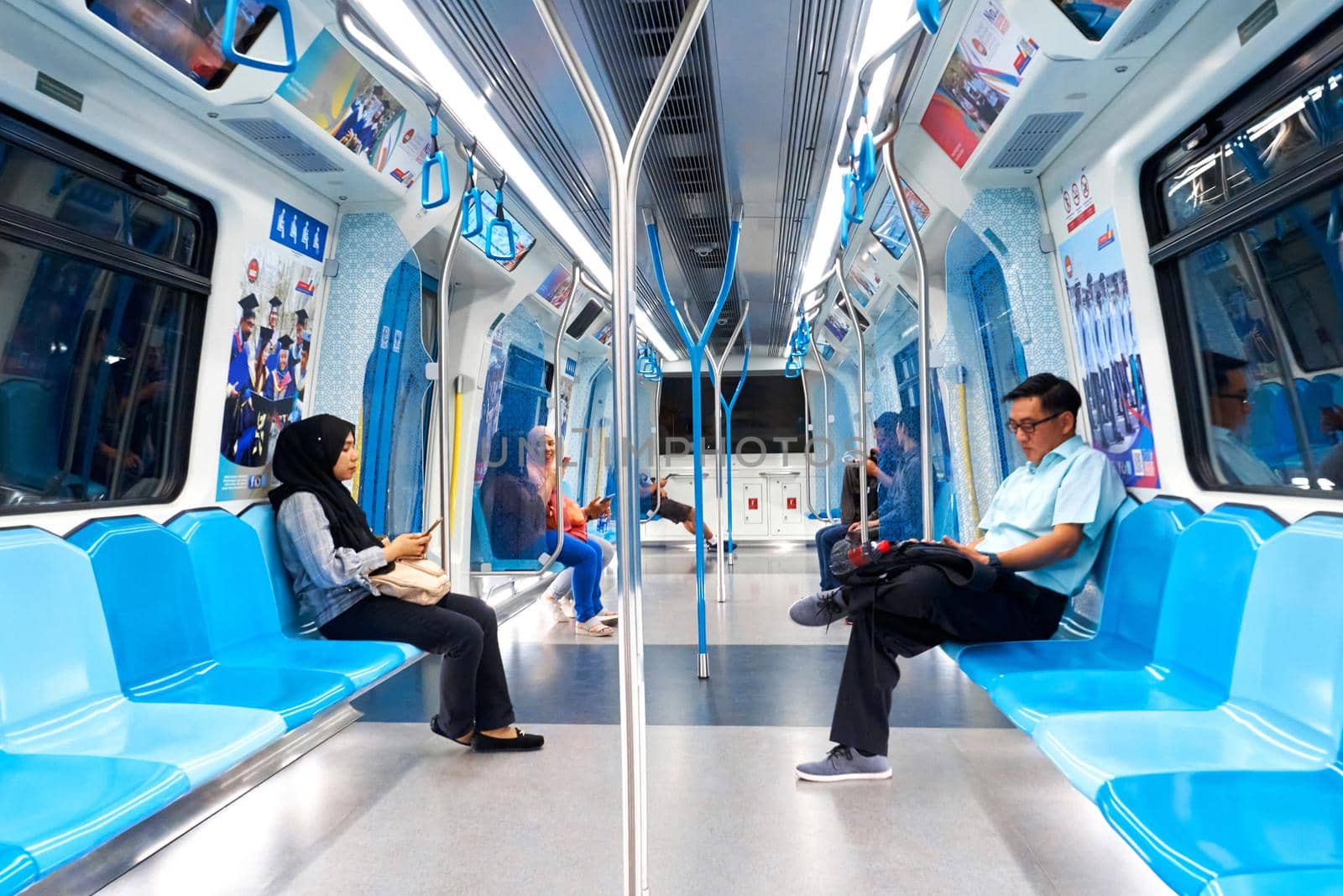 The interior of a modern subway car. New beautiful wagon. People in the subway go on business. Kuala Lumpur, Malaysia - 04.01.2020