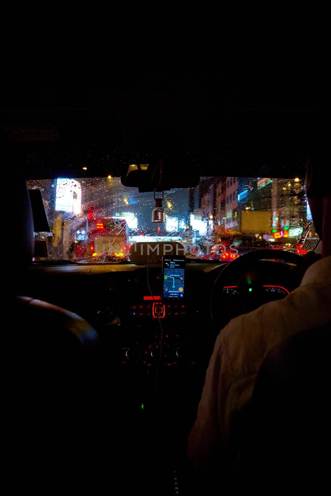 interior of a car driving night rainy city. blurred city lights. Kuala Lumpur, Malaysia - 04.01.2020