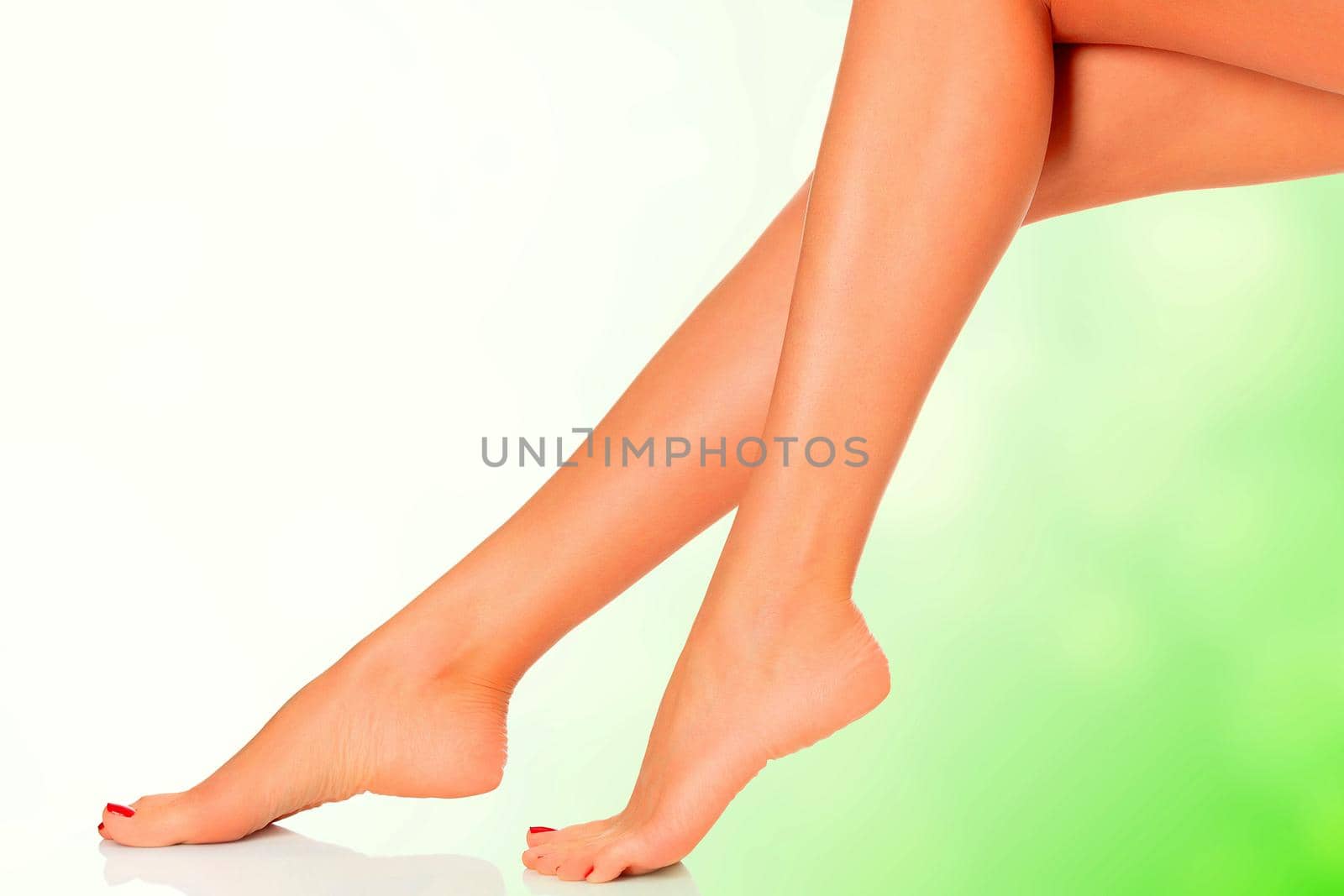 Perfect long female legs on green blurred background. by Nobilior