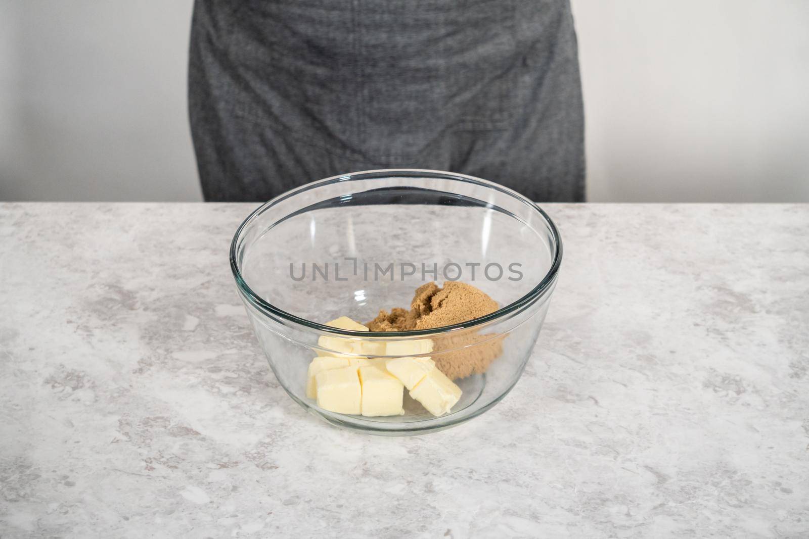 Mixing ingredients in a large glass mixing bowl to bake eggnog scones.