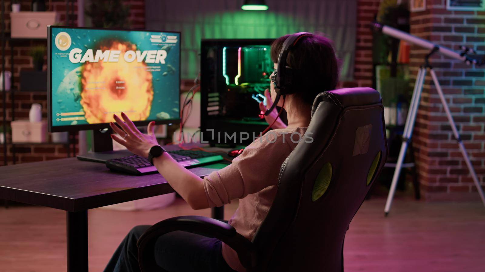 Gamer girl feeling mad shouting at computer screen after losing difficult level in online space shooter on gaming pc. Caucasian woman playing multiplayer game disappointed after failing competition.