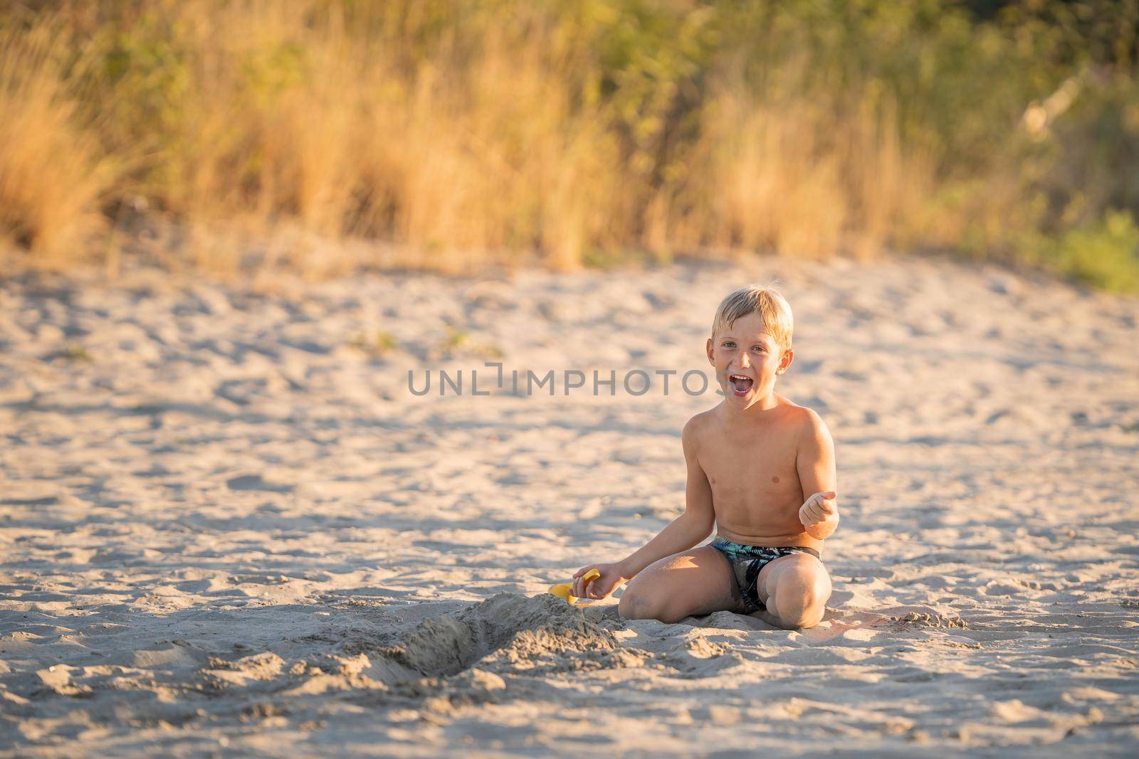 Little boy laughing on the beach summer holidays by Robertobinetti70