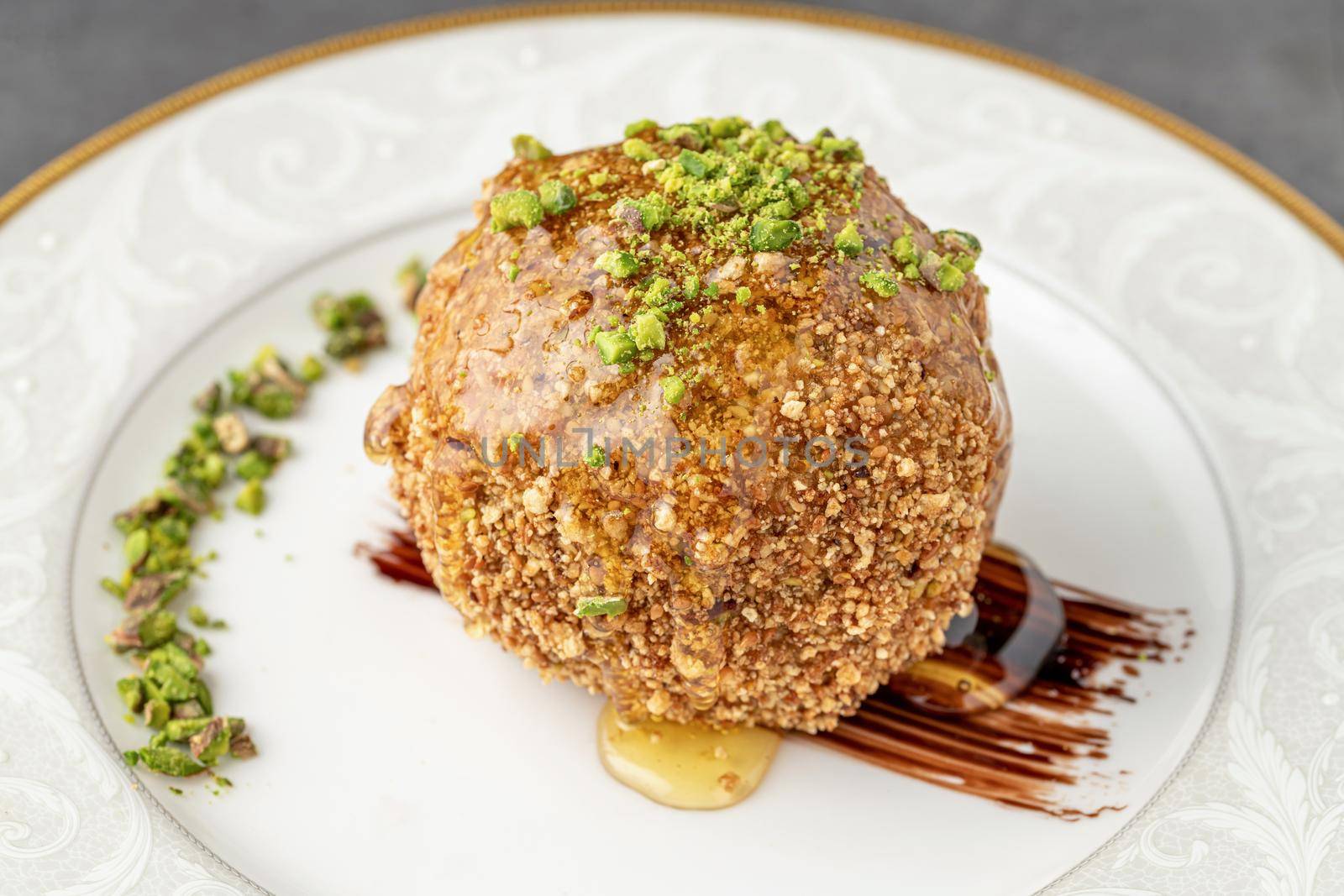 Fried ice cream sprinkled with peanuts on a white porcelain plate by Sonat