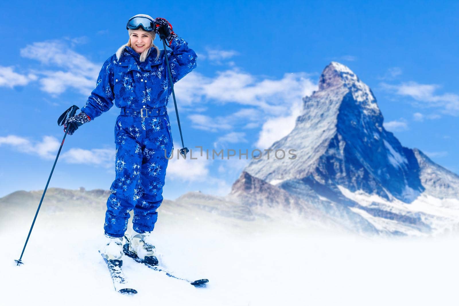female wearing sports jacket and goggles who hands skis.