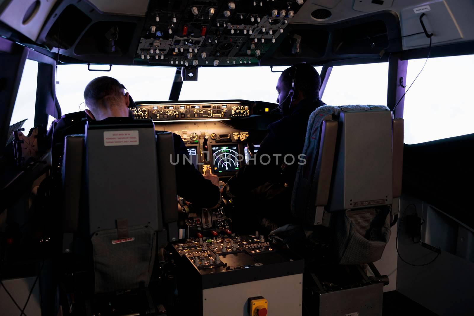 Multiethnic team of pilots using control command to fly plane by DCStudio