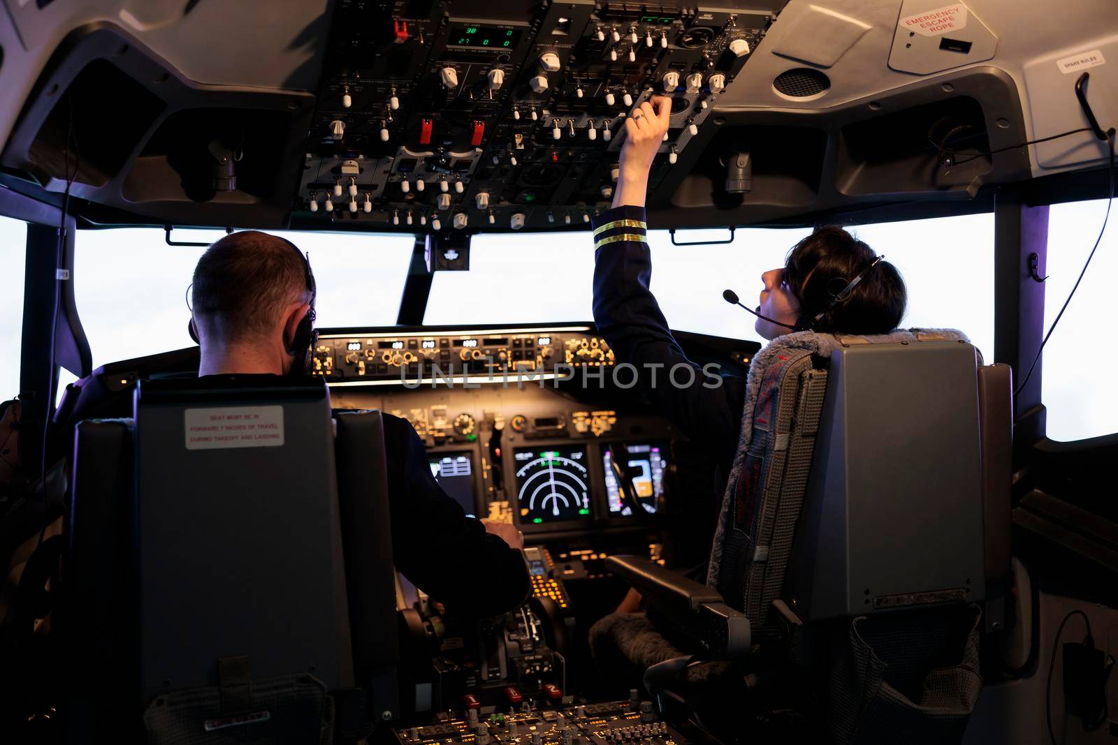 Aircrew members flying airplane with dashboard command, using control panel and navigation windscreen. Piloting aircraft with power lever switch and handle in aviation cockpit cabin.